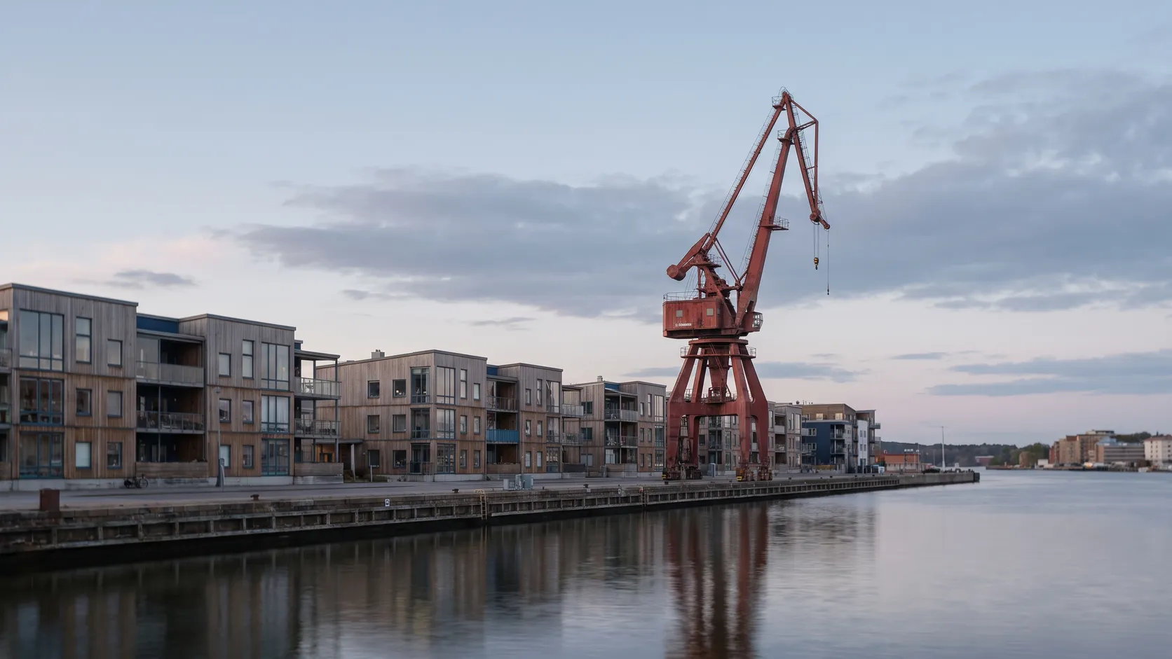 Kaj på Hisingen med en stor röd varvskran och bostadshus vid älven.