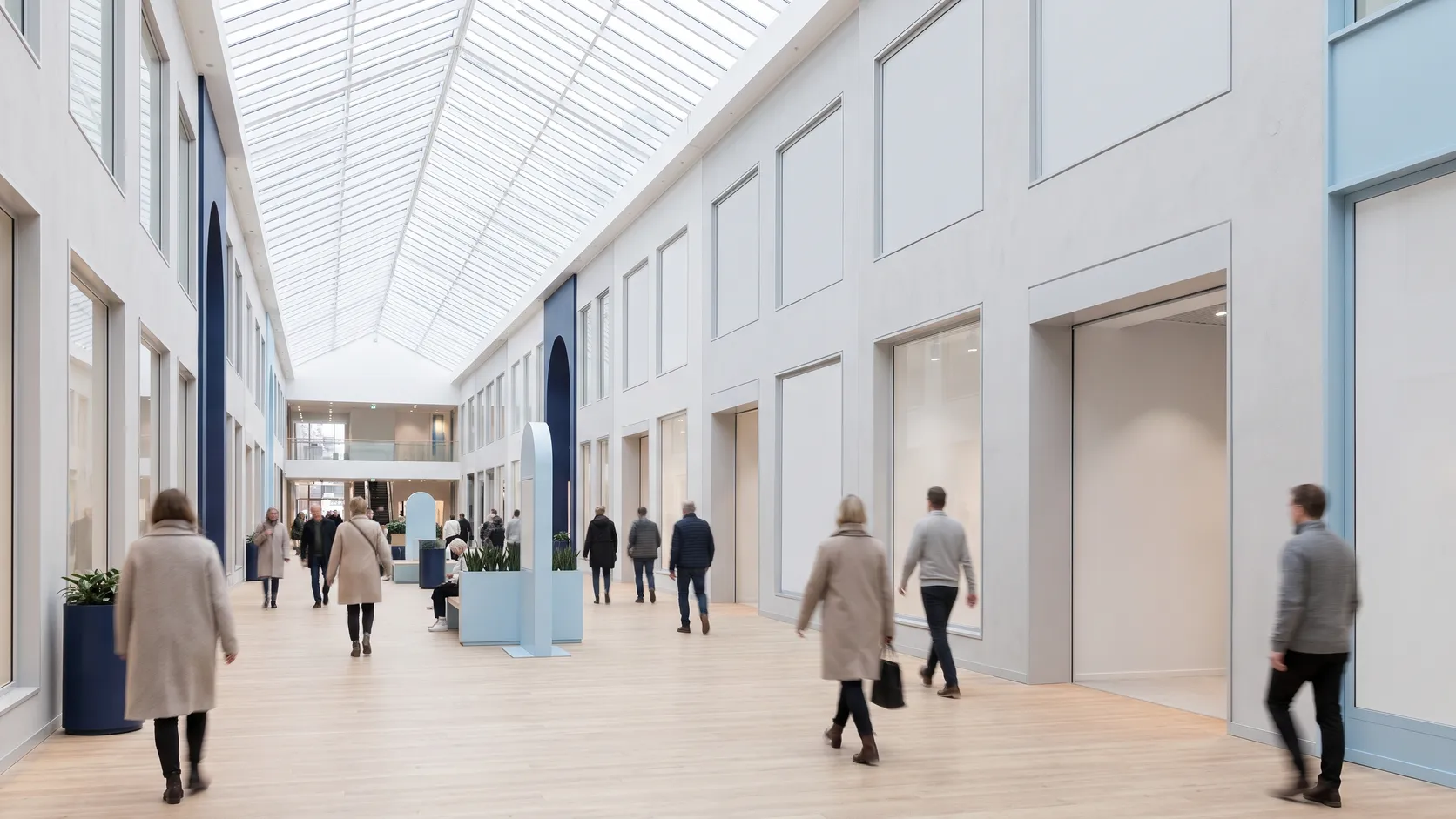Inomhusgalleria med glastak och människor som går förbi.
