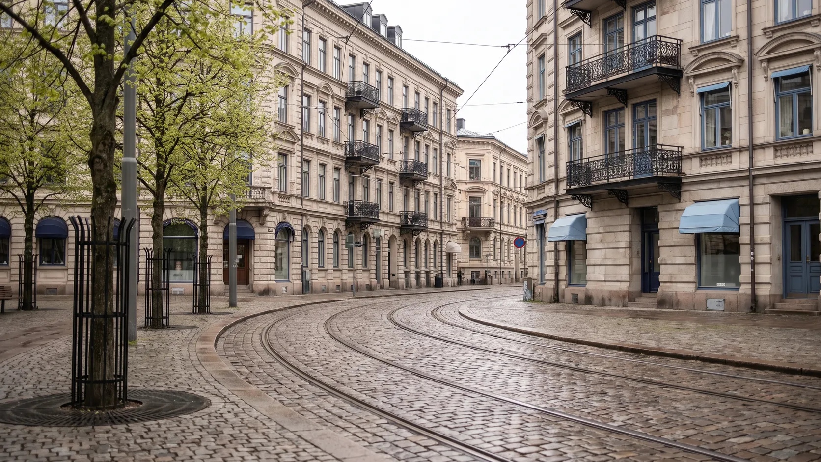 Stenhus och spårvagnsspår vid en trädkantad plats i Vasastan.